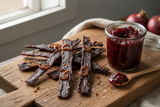 caramelised red onion long dry jerky strips on a board with a jar of red onion chutney